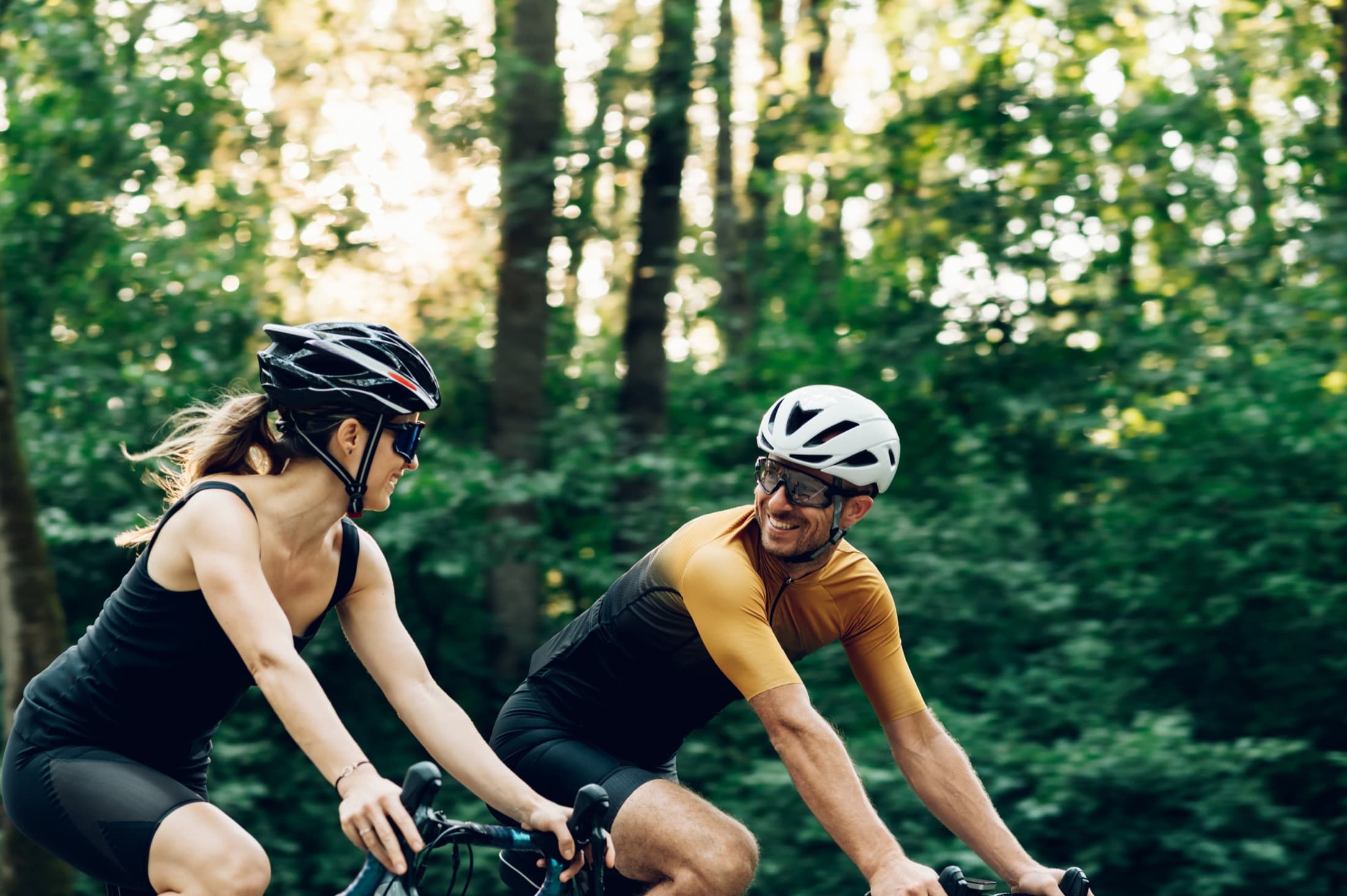 Cyclists riding through a green forest